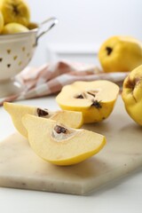 Tasty ripe quinces on white wooden table, closeup