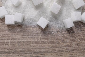 Different types of white sugar on wooden table, top view. Space for text