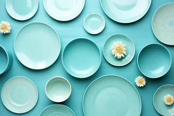 Foto op Canvas A creatively arranged top view of various light blue ceramic plates and bowls with subtle white flower decorations. Flat Lay Top View Creative Color Design Concept © guruXOX