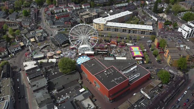 Aerial view arriving at fair showing funfair attractions like ferris wheel and wave swinger is amusement ride that is a variation on the carousel in which the seats are suspended from rotating 4k