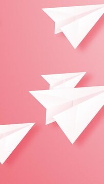 Flying white color paper planes over red color background. Vertical resolution Video.