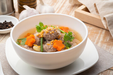 Close up Clear glass noodle soup with Minced Pork and carrot.Asian Meatball Soup with cellophane noodle (Gaeng Jued Woon Sen)
