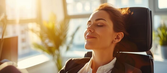 Relaxing businesswoman with eyes closed in a modern, sunny office.