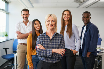 Group portrait of female entrepreneur with group of colleagues standing together at office - obrazy, fototapety, plakaty
