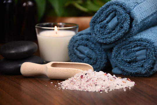 Blue-green towels, salt and candle on wooden background spa still life stock photo images. Spa and wellness setting with towels, candle and bath salt photo. Beauty spa treatment composition photo