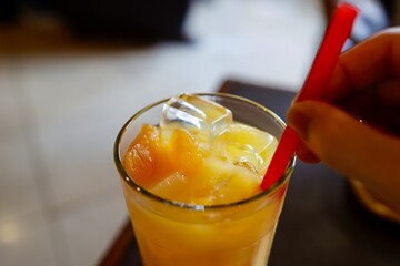 氷とみかんの果肉が入った冷たいオレンジジュース