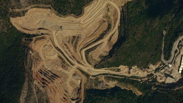 vue a&eacute;rienne drone satellite topshot d'une carri&egrave;re de pierre au milieu de la for&ecirc;t avec v&eacute;hicules qui se d&eacute;placent