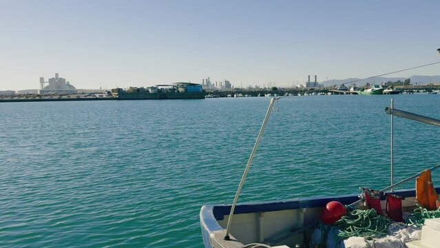 Fishing boats and ships in the port of Castellon in winter. Port cranes on the horizon. Red floats for nets. Port of El Grao. Spain