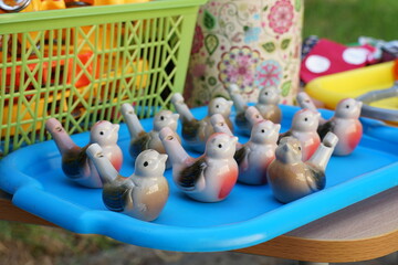 Many children's ceramic whistles in the shape of a bird on a tray