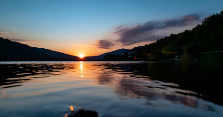 sunset over a serene lake, with colorful reflections shimmering