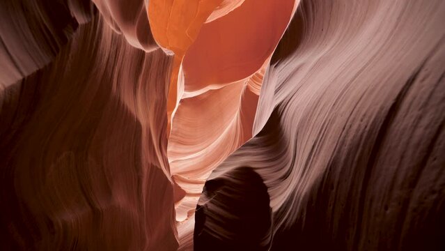 Movement in deep slot canyon with curved and smooth sandstone massive vertical walls of bright red orange color, amazing rock formations antelope canyon, fantastic place to hiking tourist in usa park