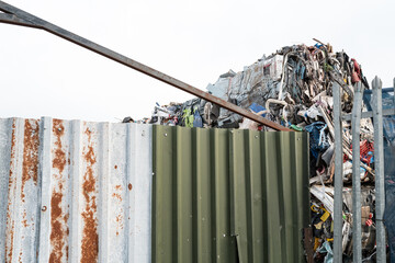 Compressed commercial dry waste seen heaped within the boundary of a waste disposal factory. 