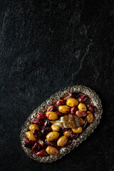 Spicy olives on a black stone table.