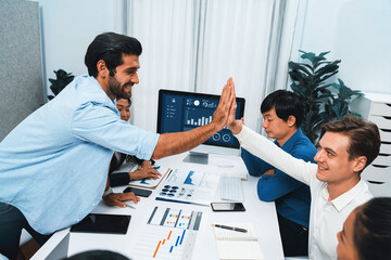 Analyst team leader celebrate and high five together with his colleague after successful data...
