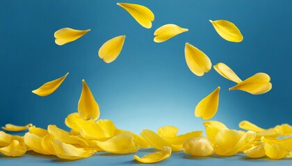 Yellow flying petals of tulip in blue studio