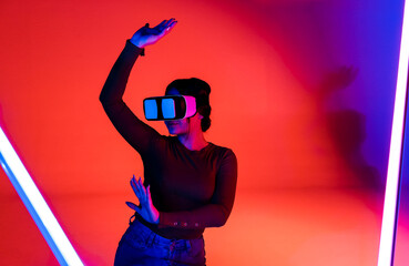 Cheerful woman in VR glasses under neon light