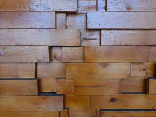 A decorative wooden wall panel featuring staggered rectangular blocks in a three-dimensional design. This rustic wood texture creates an abstract background for modern interior concepts.