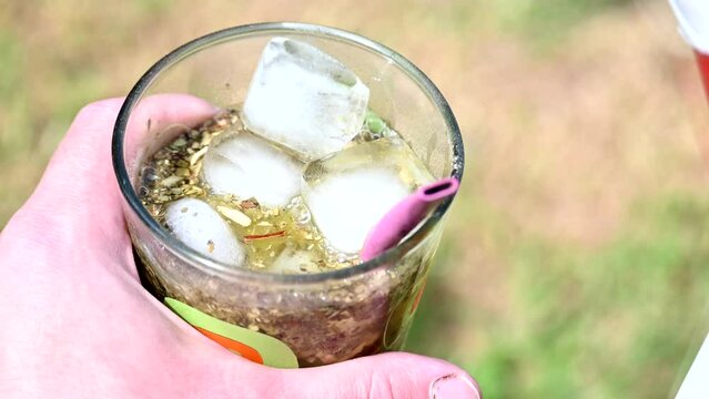 Serving Terere in a glass, cold yerba mate infusion with ice and juice.