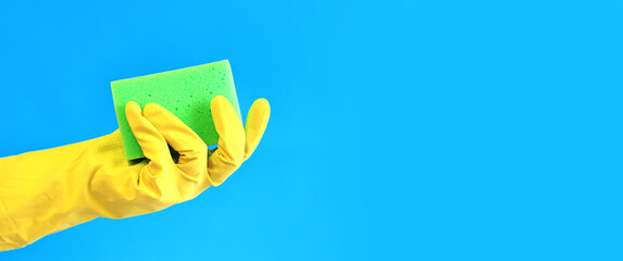 Female hand in latex gloves hold sponge for washing dishes. Cleaning the premises. Professional...