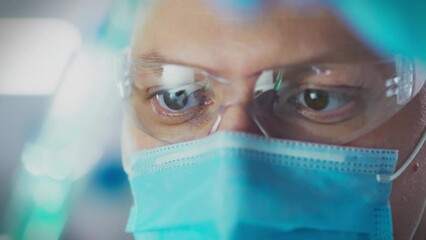 Virus. A microbiology doctor wearing safety glasses carefully analyzes liquids in research center. camera in motion, microbiology specialist experiments with substances, antivirus development, health