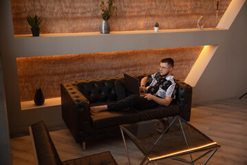 A man with glasses works at a laptop