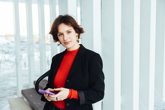 Young Businesswoman using cell phone. Female enterpener using mobile for texting. A confident millennial woman