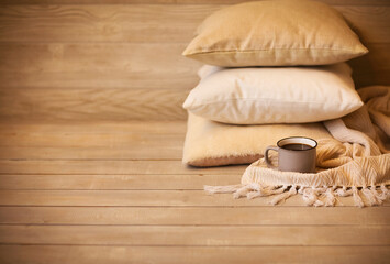 Fototapeta na wymiar Comfortable background with cushions and mug of hot drink in cozy living room