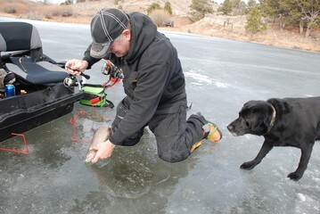 Ice angler with a trout caught through the ice