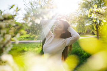 A young beautiful woman relaxes in a wonderful blooming spring garden at sunset. The concept of...