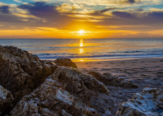 Obraz premium Golden sunrise over a rugged coastline, perfect for inspirational themes, travel promotion, and natural landscape photography.