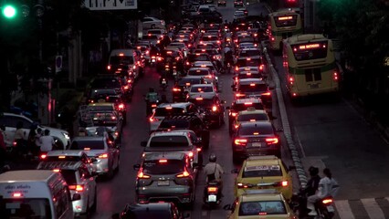 Timelapse of night traffic jam in Bangkok, Thailand, during rush hour in downtown. Capturing the motion of car tail lights and red stop signals, with vehicles moving through the cityscape. Showcasing 
