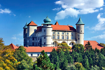 View on castle Nowy Wisnicz in Poland in sunny autumn day on a background of blue sky with white...