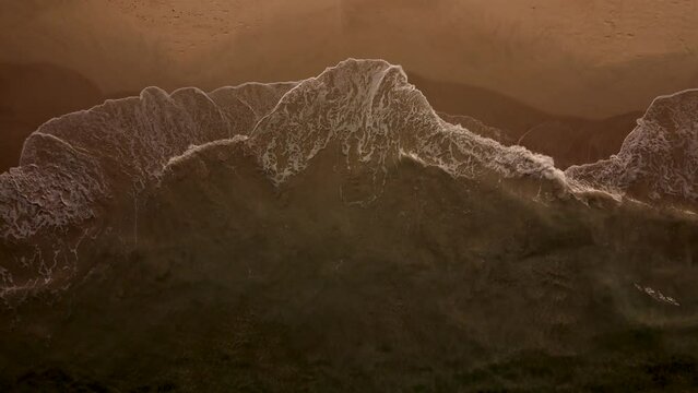 Aerial overhead drone shot of waves breaking on the sand in the dark