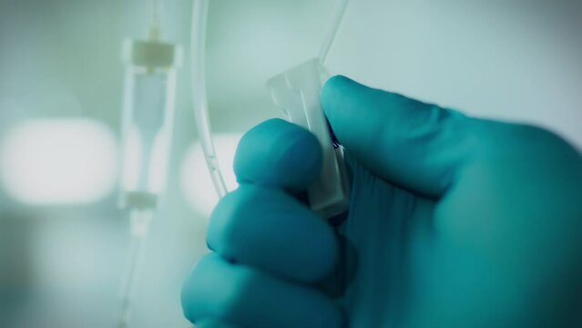 Operating room. An anesthesiologist in special clothes drips IV drip drops in the ward. General perspective qualified doctor treating patient with iv drip professional patient care, medication
