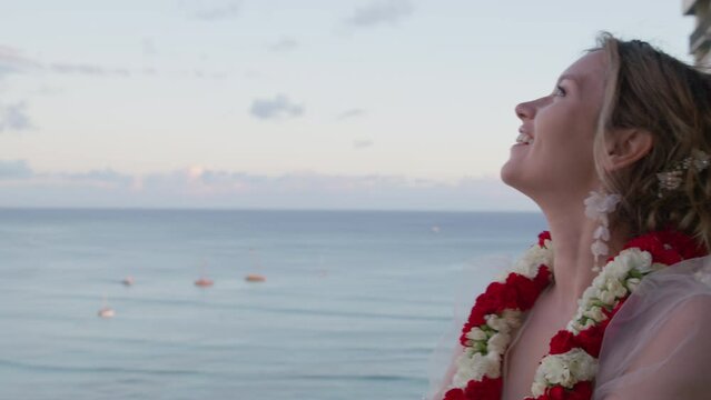 Portrait of smiling young woman looking at hand with diamond ring. Happy bride enjoying amazing Diamond Head volcano landmark after wedding ring on beautiful Waikiki beach, Oahu island, Hawaii USA 4K