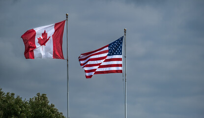 American and Canadian flags together. American and Canadian flags flying side by side at the border between USA-Canada