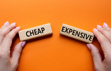 Cheap or Expensive symbol. Concept word Cheap or Expensive on wooden blocks. Businessman hand....