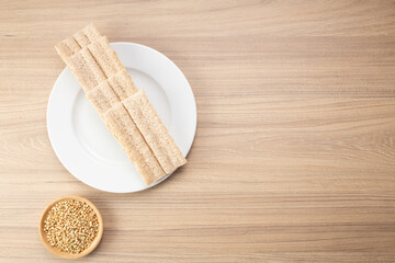 Buckwheat crisp bread and buckwheat on plate on wooden background, gluten free. Dietary cookies