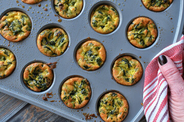 A baking pan of mini spinach quiches, bite-size quiche. 