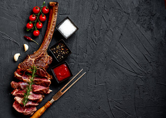 Grilled Tomahawk steak on stone background with copy space for text

