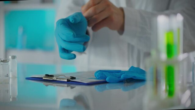 An Experienced Scientist Slowly Puts On Nitrile Gloves In A Research Center. General View Of An Experienced Professional Putting On Protective Gloves Developing A Vaccine, Researching