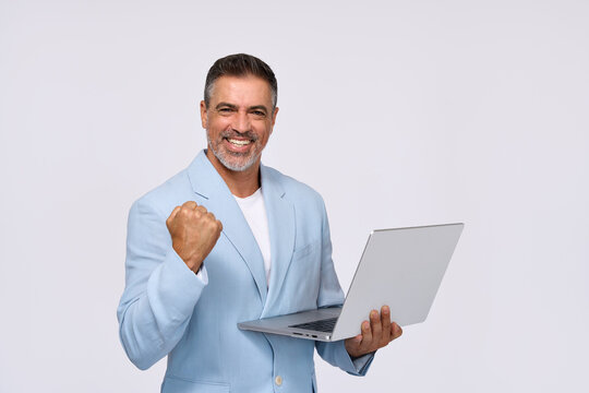 Happy middle aged business man entrepreneur, excited older professional businessman winner wearing suit holding laptop celebrating online win, business success standing isolated on white background.