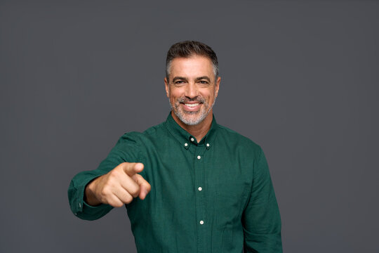 Happy middle aged business man, smiling older professional businessman employer looking at camera pointing finger making choice selecting you standing isolated on gray background.