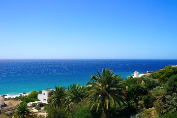 view over palms, exotic plans and villas towards the Atlantic Ocean, Playa Los Alemanes, Atlanterra, Faro de Camarinal, Costa de la Luz, Atlanterra, Andalusia, Spain © keBu.Medien