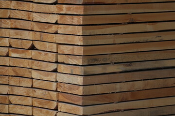 Perspective angle of wooden planks in close-up at a lumber warehouse. Background of boards.
