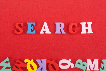 SEARCH word on red background composed from colorful abc alphabet block wooden letters, copy space for ad text. Learning english concept.