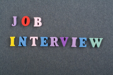 JOP INTERVIEW word on black board background composed from colorful abc alphabet block wooden...
