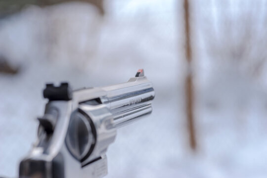Polska Ćmielów 10 grudnia 2023 godz 11:43 . Rewolwer Smit and Wesson 357 Magnum w ręku strzelca na sportowej strzelnicy w śnieżnej aurze.