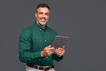 Smiling mature businessman professional executive manager looking at camera holding tab device,...