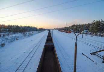 Bocznica kolejowa - rozjazd na terenie huty w zimowej aurze w lesie. Pociąg towarowy stojący na...